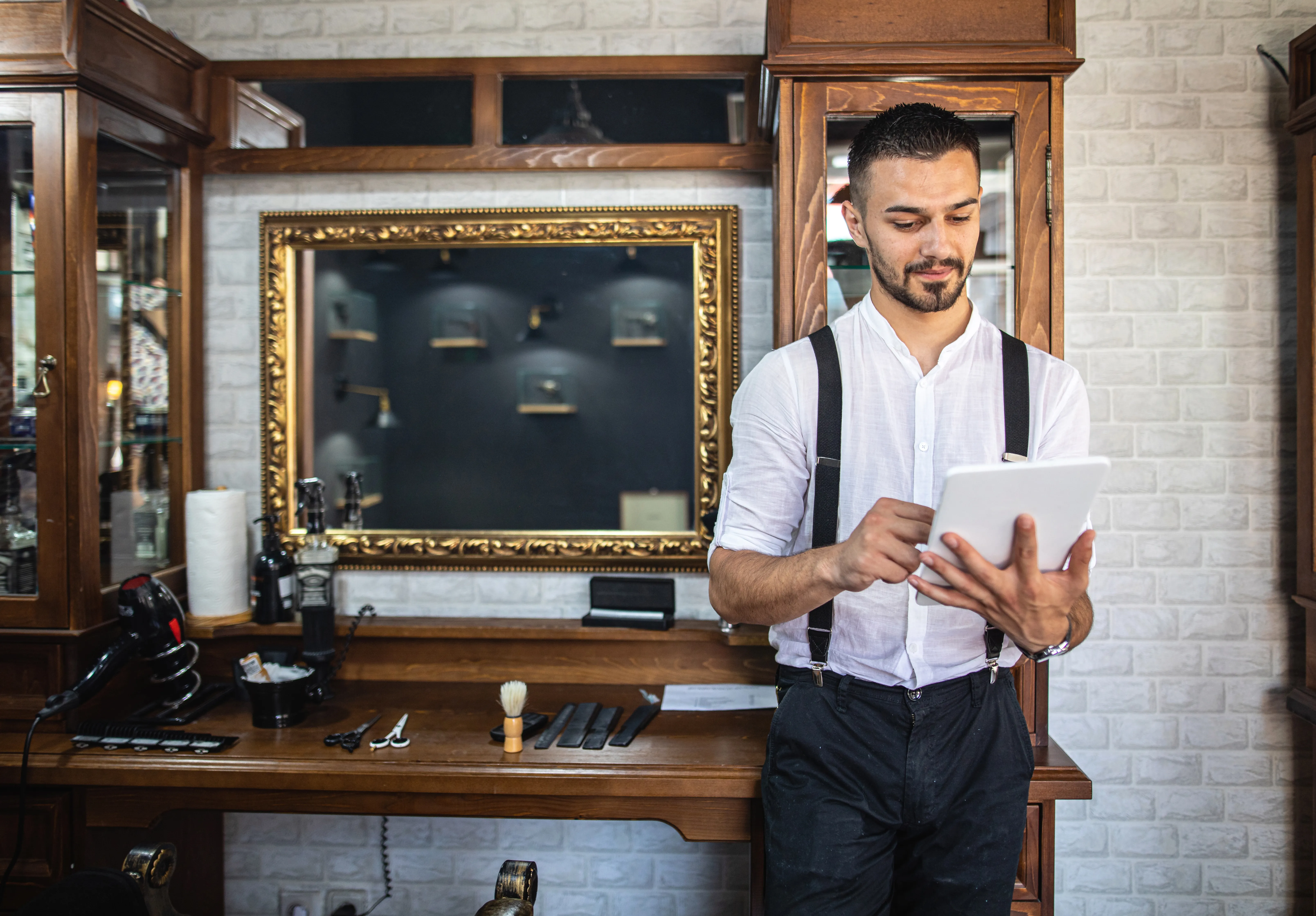Friseur im Barbershop mit Tablet