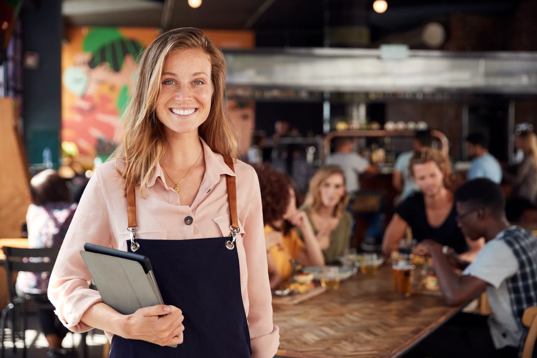 Servicekraft mit Tablet im gut besuchten Restaurant